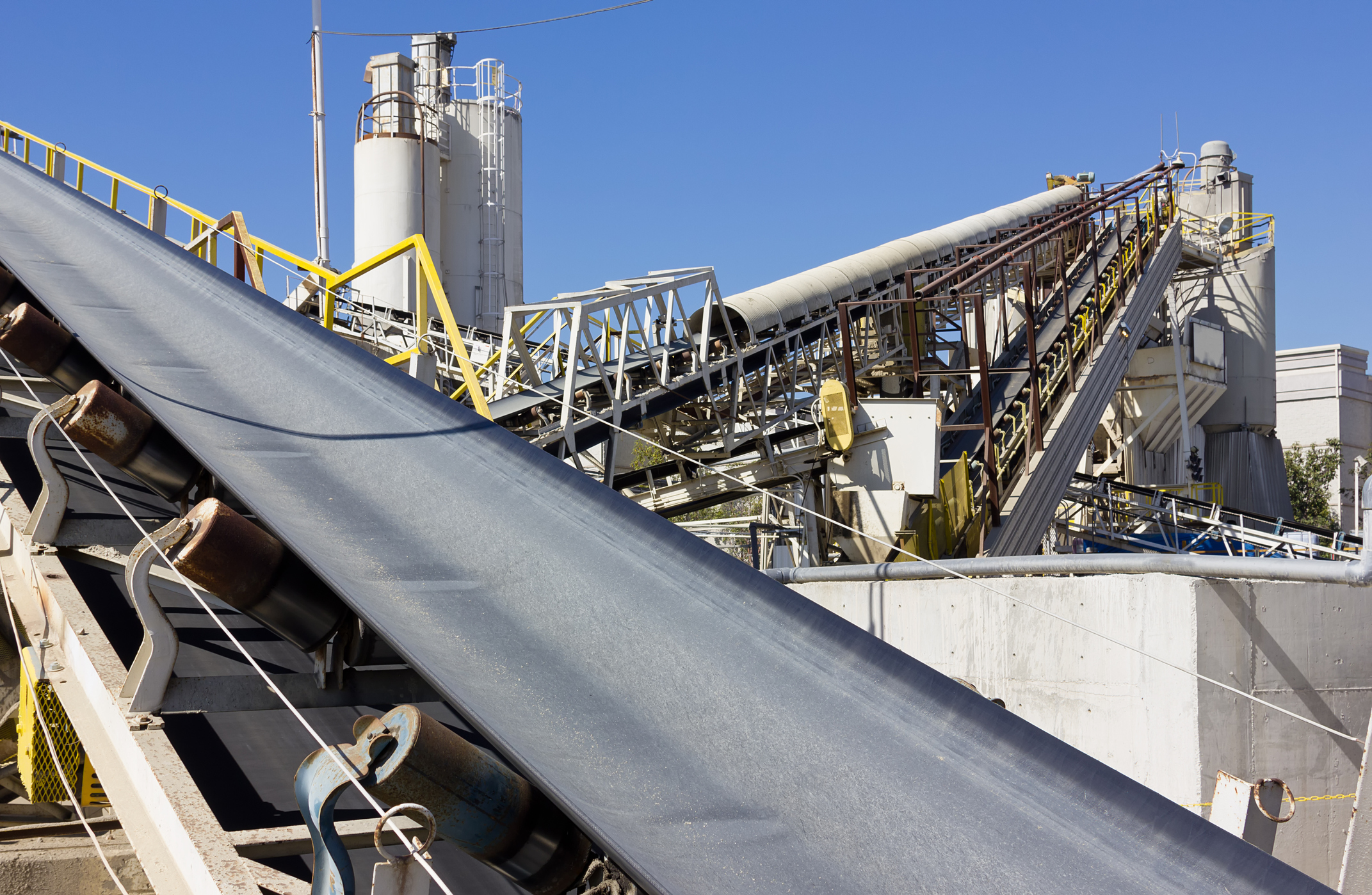 Multiple industrial conveyor belts are used at a processing site.